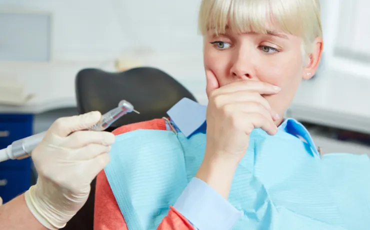 Calm dentist explaining sedation options to an anxious adult patient in a modern dental office, emphasizing comfort and trust