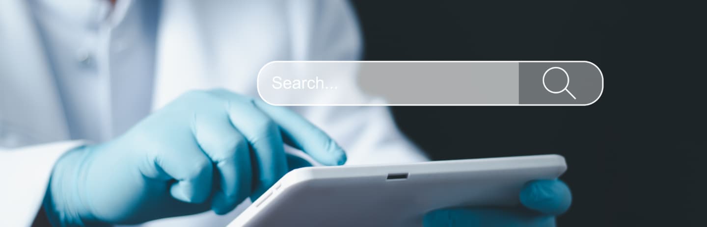 Dentist reviewing dental website SEO analytics on laptop while smiling patient waits in modern clinic reception area