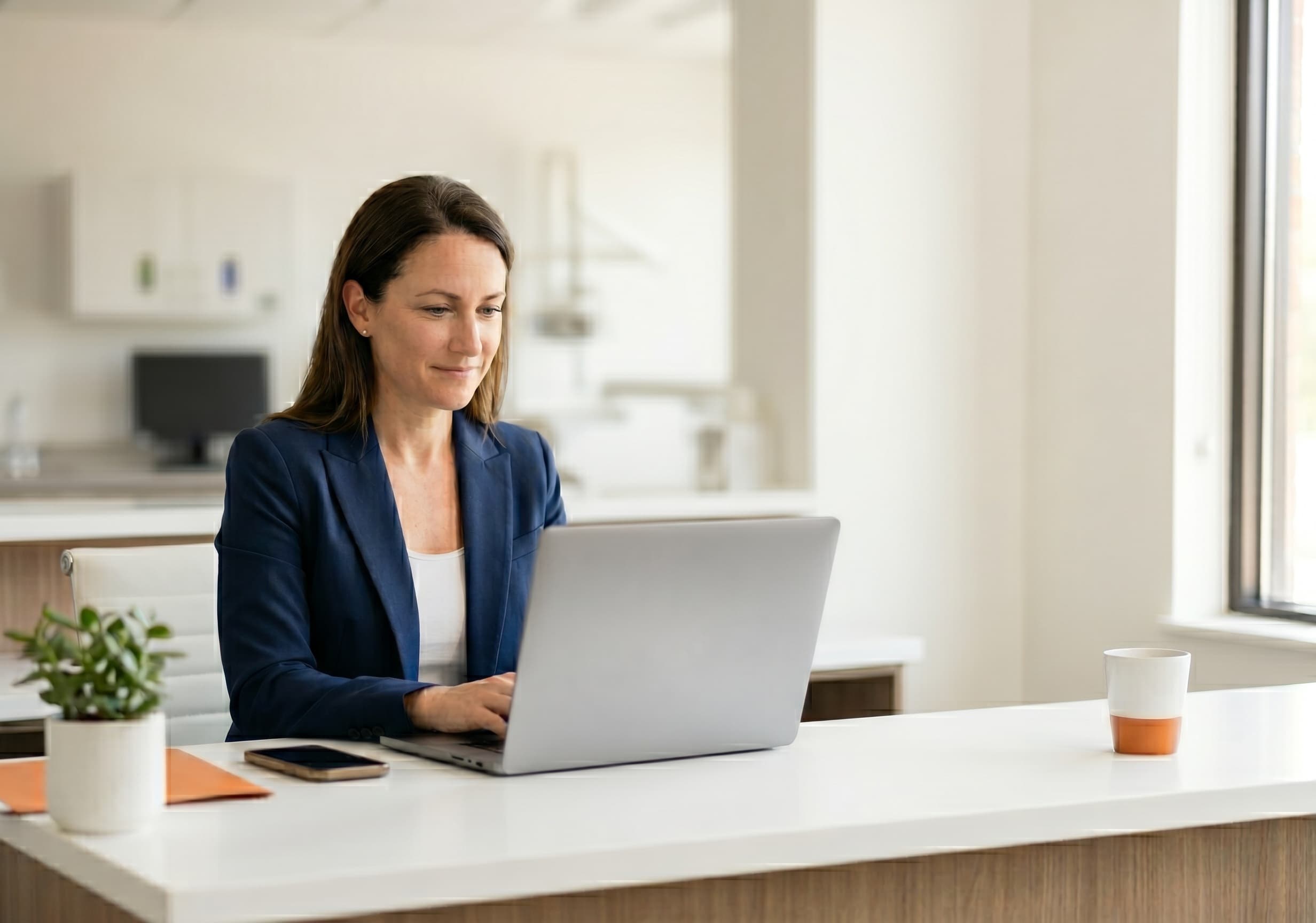 Dentist reviewing dental website SEO analytics on laptop while smiling patient waits in modern clinic reception area
